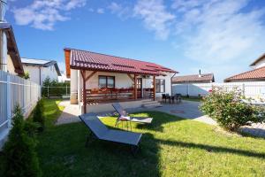a small yard with a house with a bench at Mountain View House Brasov in Braşov