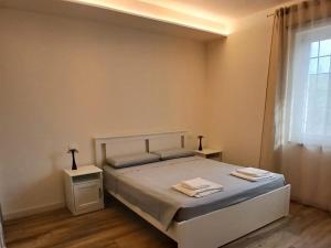 a bedroom with a bed with two tables and a window at Il Rifugio in Franciacorta in Erbusco