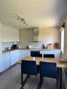 a large kitchen with a wooden table and chairs at Bright apartment in Haslum in Haslum 