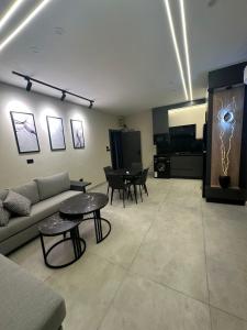a living room with a couch and a table at Trio Luxury Apartment 3 in Sowayma