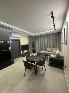 a living room with a couch and a table and chairs at Trio Luxury Apartment 3 in Sowayma