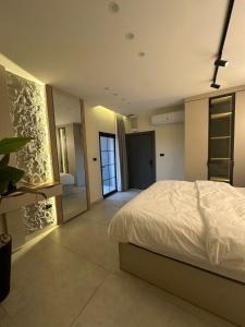 a bedroom with a white bed and a mirror at Trio Luxury Apartment 3 in Sowayma