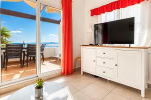 a living room with a tv and a large window at Ibiza Bramer 7 - ImmoBarneda in Roses