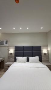 a bedroom with a large white bed with two pillows at الأمان للشقق المخدومة Alamaan Serviced Apartments in Medina +68 photos
