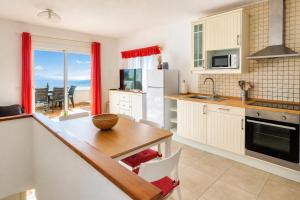 a kitchen with a table and a view of the ocean at Ibiza Bramer 7 - ImmoBarneda in Roses +25 photos