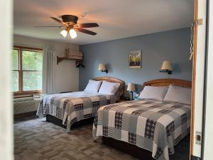 a bedroom with two beds and a ceiling fan at Little Bluff Inn in Trempealeau