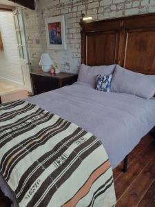 a bedroom with a large bed with a wooden headboard at Room at Lindley in Ludlow