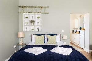a bedroom with a blue bed with towels on it at Beautiful Cotswold Couples Retreat in Bourton on the Water