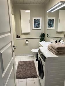 a bathroom with a sink and a washing machine at Bright apartment in Haslum in Haslum 