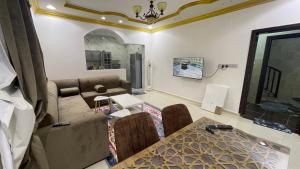 a living room with a couch and a table at شقق مفروشة الطارق in Ḩaql