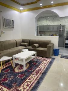 a living room with a couch and a table at شقق مفروشة الطارق in Ḩaql