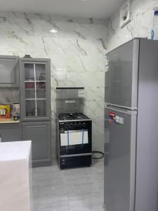 a kitchen with a stove and a refrigerator at شقق مفروشة الطارق in Ḩaql