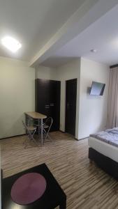 a room with a bed and a table and a table at Aparthouse Kretowiny in Kretowiny