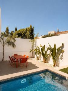 a patio with a table and chairs next to a swimming pool at Villa Bazaruto in Lagos