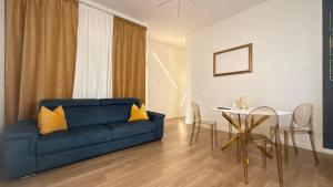 a living room with a blue couch and a table at Color Houses Pescara Centro in Pescara