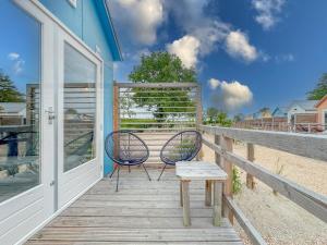 a porch with two chairs and a bench on it at Bleu Dream in Ellemeet