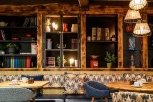 a restaurant with two tables and chairs and books at The Old Bridge Inn, Holmfirth, West Yorkshire - The Coaching Inn Group in Holmfirth
