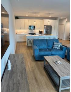 a living room with a blue couch and a kitchen at Wake Up in Wildwood in Wildwood
