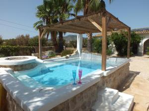 a swimming pool with a pergola and two glasses in it at Buena Idea - Adults Only in Jalón