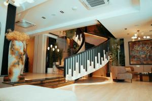 a lobby with a staircase with a vase at Taj Premium Hotel in Baghdād