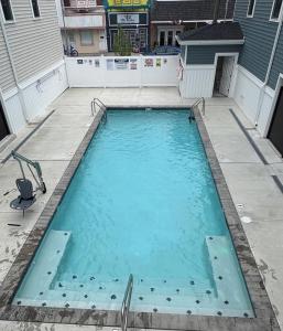a large swimming pool on a sidewalk next to a building at Wake Up in Wildwood in Wildwood