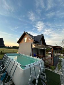 a house with a pool in front of a house at Noclegi u Dąbka 2 in Głębokie +5 photos