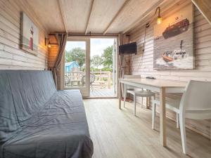 a bedroom with a bed and a desk and a table at Seaside Blue in Ellemeet