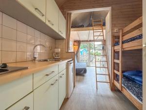 a kitchen with a staircase leading to a bunk bed at Seaside Blue in Ellemeet