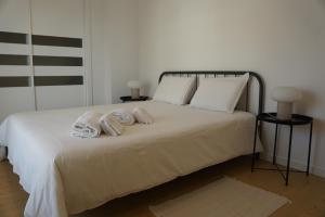 a bedroom with a bed with towels on it at Alfaiate Beach House in Santa Cruz