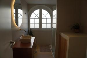 a bathroom with a bowl sink and a mirror at Alfaiate Beach House in Santa Cruz +26 photos