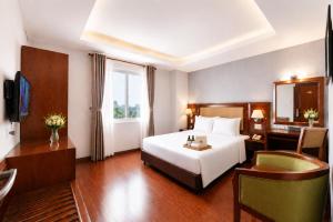 a hotel room with a large white bed and a desk at G8 Diamond Hotel Saigon in Ho Chi Minh City +79 photos