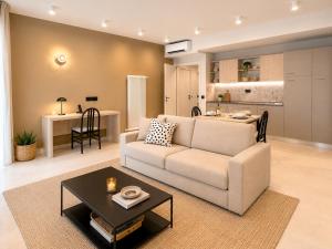 a living room with a couch and a table and a kitchen at Residence Danio in Alassio