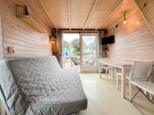 a bedroom with a bed and a desk and a table at Sea Foam in Ellemeet