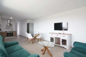 a living room with a couch and a tv at La Morada de Sasa Casa tierra in Torrent