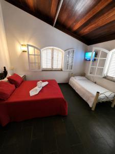 a bedroom with two beds and a red blanket at Recanto Tia Nena in Araruama