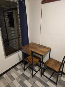a wooden table and a chair next to a window at casa luca in San José