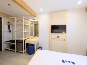 a bedroom with a bed and a desk and a shelf at Kokotel Cebu Capitol in Cebu City +18 photos