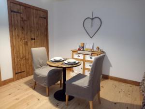 a room with a table and two chairs and a desk at La Grange des Lavandes in Mérinchal +10 photos