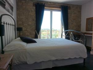a bedroom with a bed and a large window at La Grange des Lavandes in Mérinchal