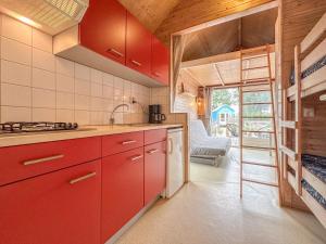 a kitchen with red cabinets and a view of a room at Sea Foam in Ellemeet +23 photos