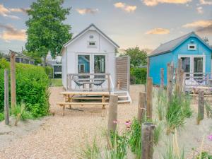 a tiny house on the beach with a bench at Sea Foam in Ellemeet