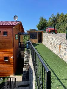 a cabin with a stone wall and a fence at Green Hill Apart in Ardeşen