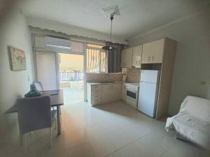 a kitchen with a table and a desk and a refrigerator at Chrisa's Home in Salamina