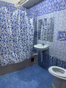 a blue and white bathroom with a toilet and a sink at Hôtel Dar Massmoudi in Tunis +28 photos