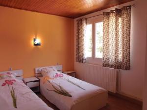 two beds in a small room with a window at Gîte Le Bouquet in Châtillon-en-Diois