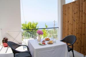 a white table with food and flowers on a balcony at Uzeiri Guest Hotel in Borsh
