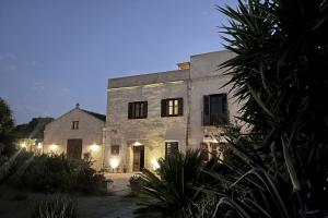 a large stone building with lights in front of it at Villa Salinara in Marsala