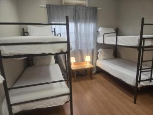 a room with three bunk beds and a small table at Residencial Sky Lounge in Lisbon