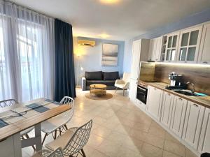 a kitchen and living room with a table and chairs at Triumph Fantastic View in Sveti Vlas