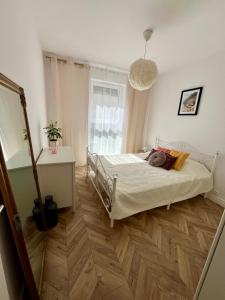 a bedroom with a bed and a wooden floor at Dolce Vita in Gdynia